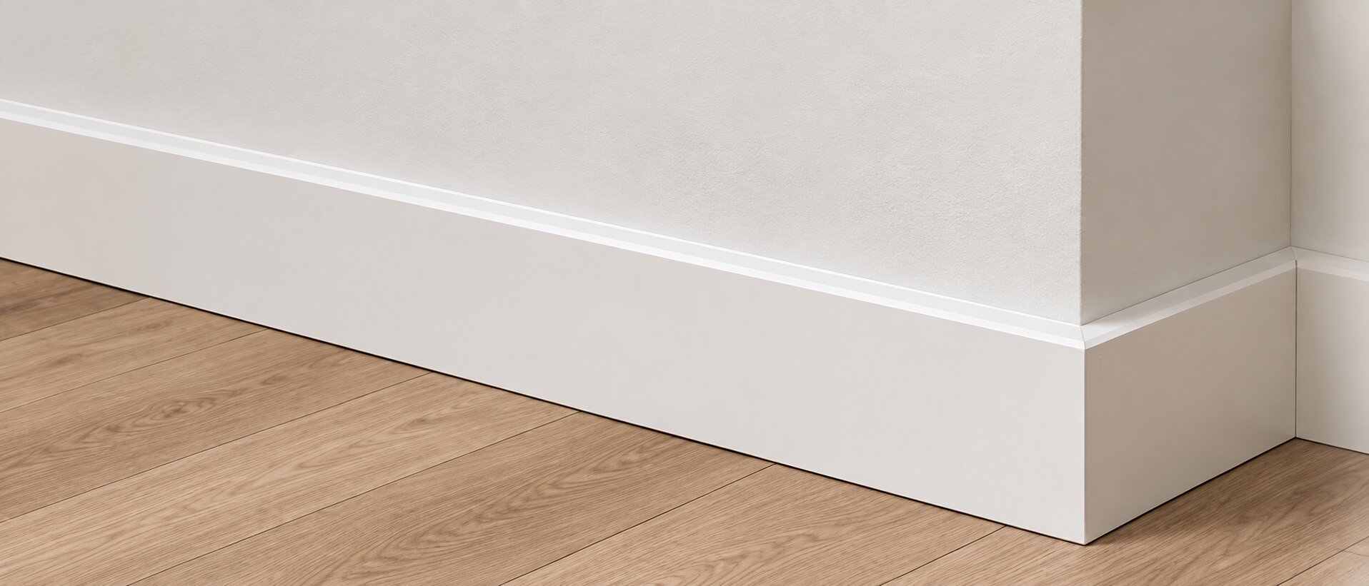 Weiße Sockelleiste am Übergang zwischen Boden und Wand